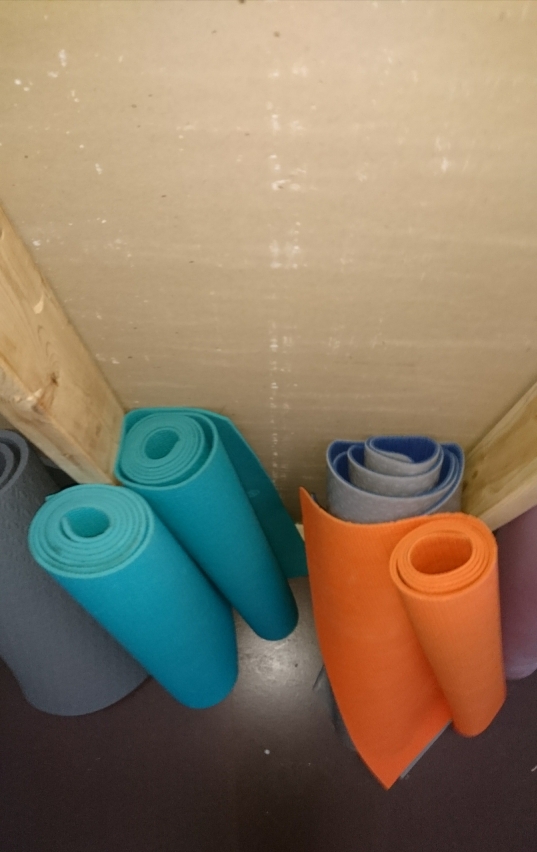Yoga mats rooled up leaning against wall