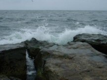 Ocean waves crashing on boulders