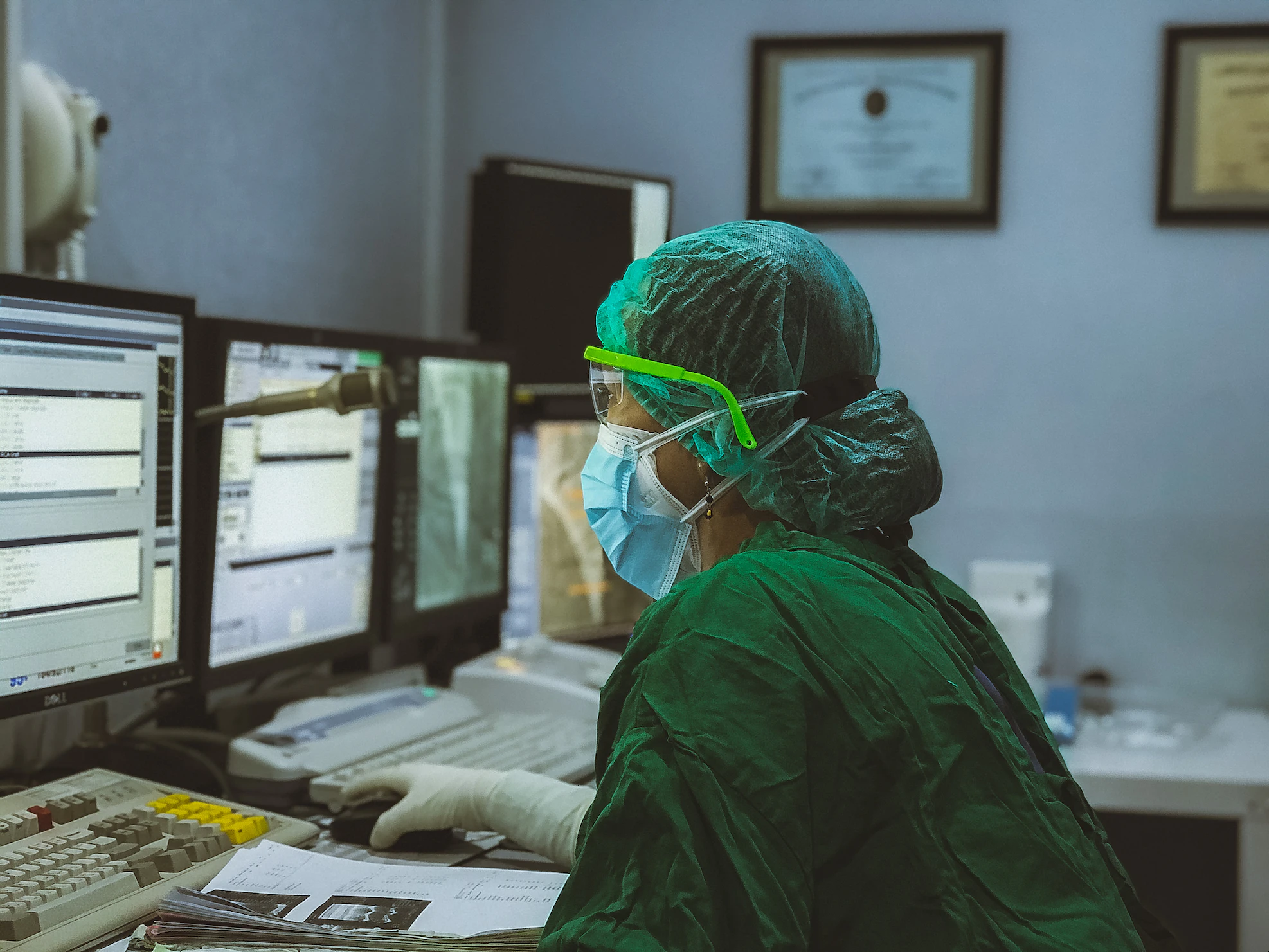 An image of an individual with medical background looking at computer