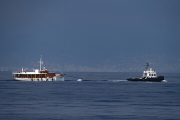 https://stock.adobe.com/images/tugboat-towing-small-boat-ship/447504752