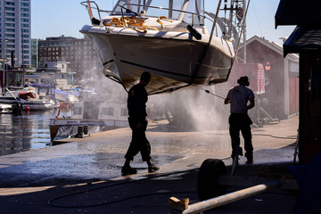 https://stock.adobe.com/images/2-people-pressure-washing-hanging-boat-in-marina/323721574