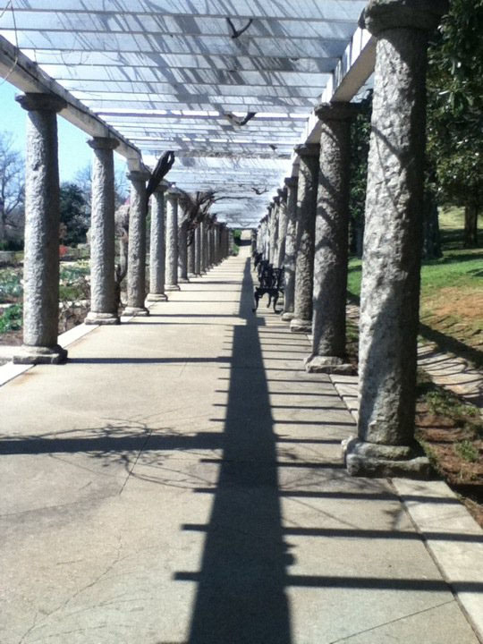 A picture taken in a park of a columned structre leading to no where.