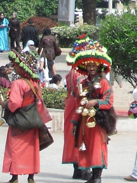 A group of men carrying water in Morroco, dressed in their native clothes.