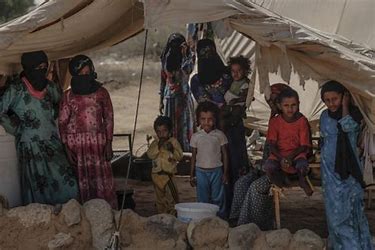 A poor Yemeni family that stands inside their tent house