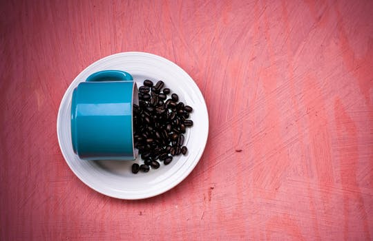 Blue Mug with Coffee Beans on Pink Background